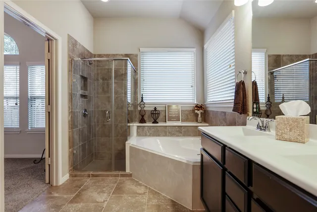 a bathroom with a tub sink and mirror