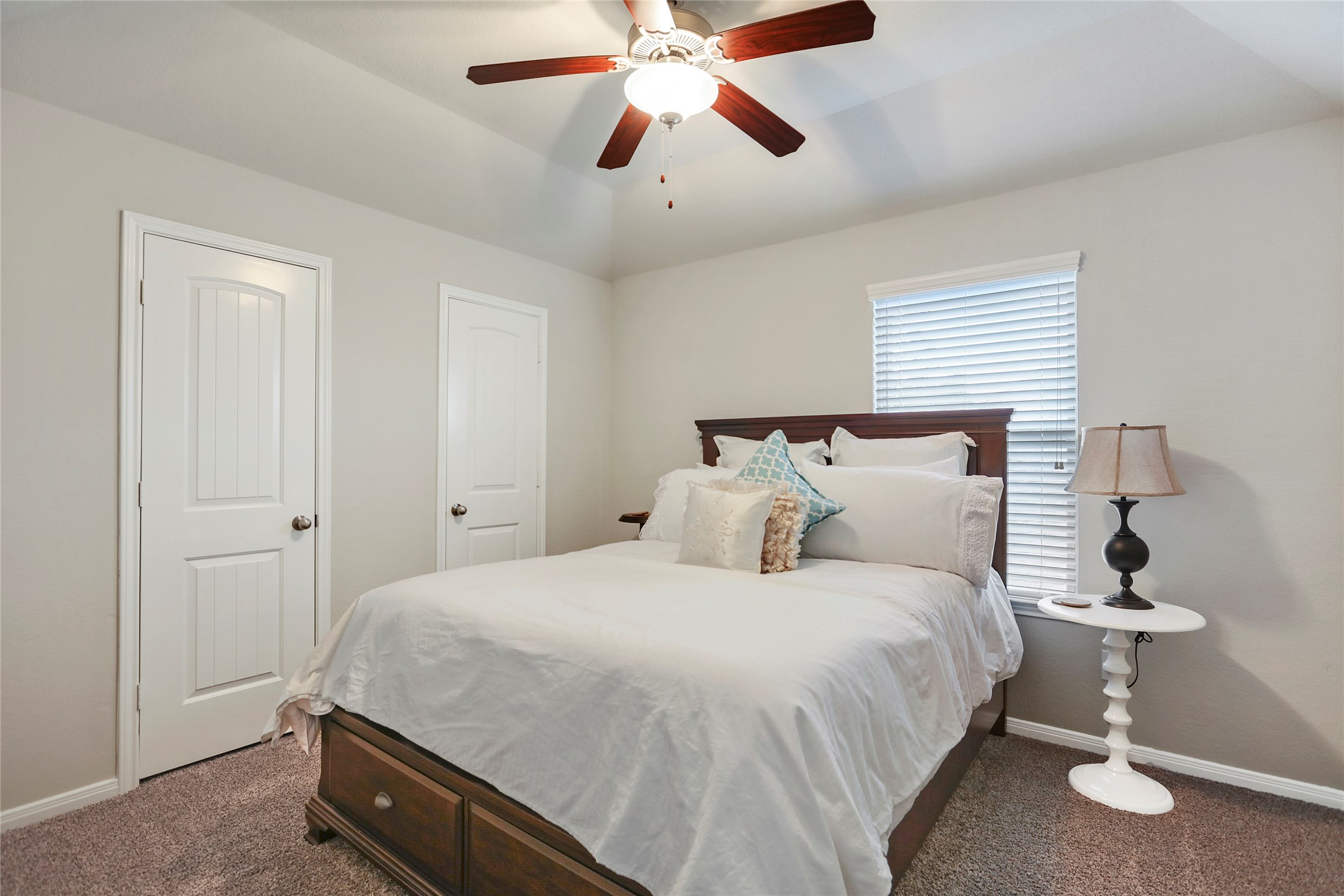 14141 Isle Royal Lane Conroe, TX 77384 - Photo 33 of 39 a bedroom with a bed and a chandelier