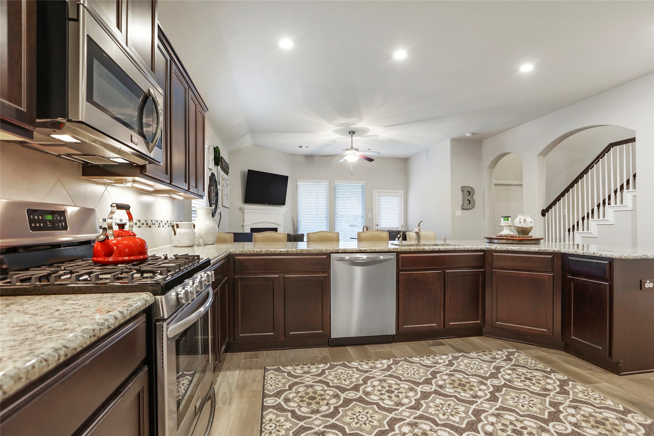 14141 Isle Royal Lane Conroe, TX 77384 - Photo 10 of 39 a kitchen with stainless steel appliances granite countertop a sink a stove and a wooden floors