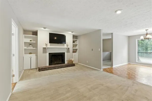 a view of an empty room with fire place and a window