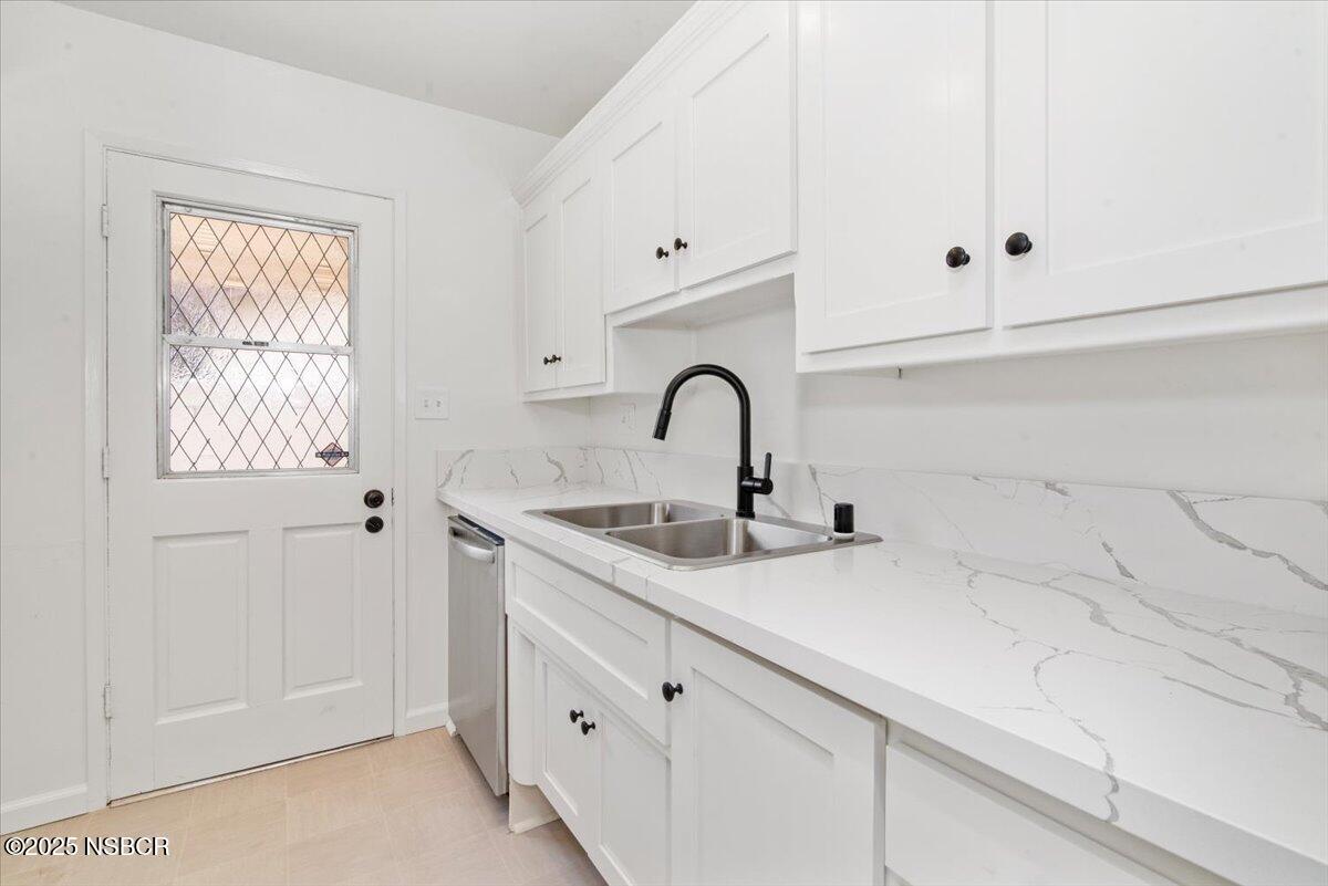 3446 Rucker Road Lompoc, CA 93436 - Photo 16 of 26 a kitchen with granite countertop white cabinets and a sink