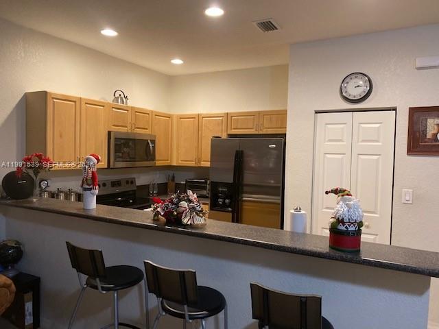 4920 Southwest 140th Terrace, Unit 4 Miramar, FL 33027 - Photo 2 of 15 a kitchen with stainless steel appliances a microwave a stove and refrigerator