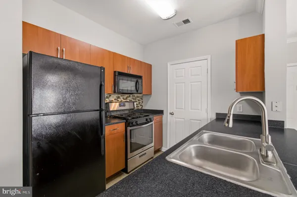 a kitchen with stainless steel appliances granite countertop a refrigerator and a sink
