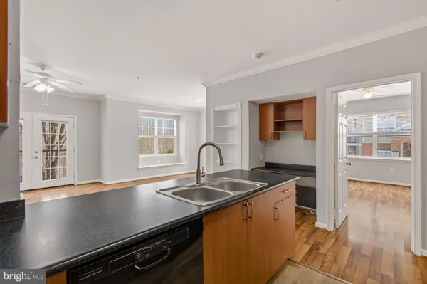 a kitchen that has a sink and a stove with wooden floor