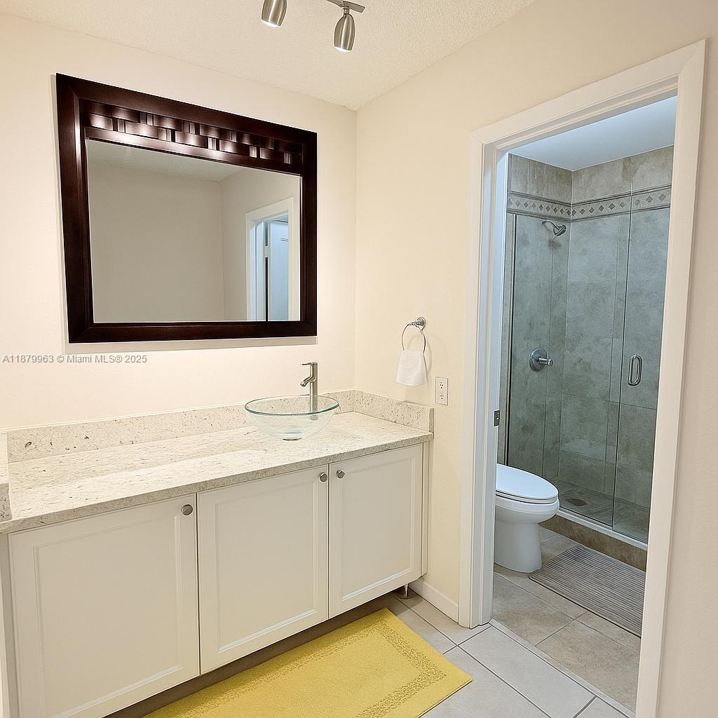 13781 Southwest 66th Street, Unit 221B Miami, FL 33183 - Photo 11 of 16 a bathroom with a toilet sink and mirror