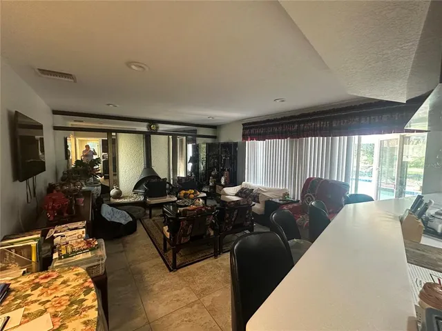 a living room with furniture large windows and flat screen tv