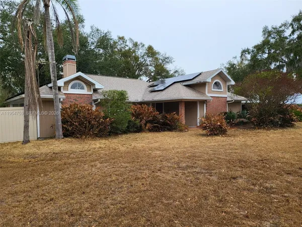 a front view of a house with a yard and tree s