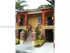 a front view of a house with plants