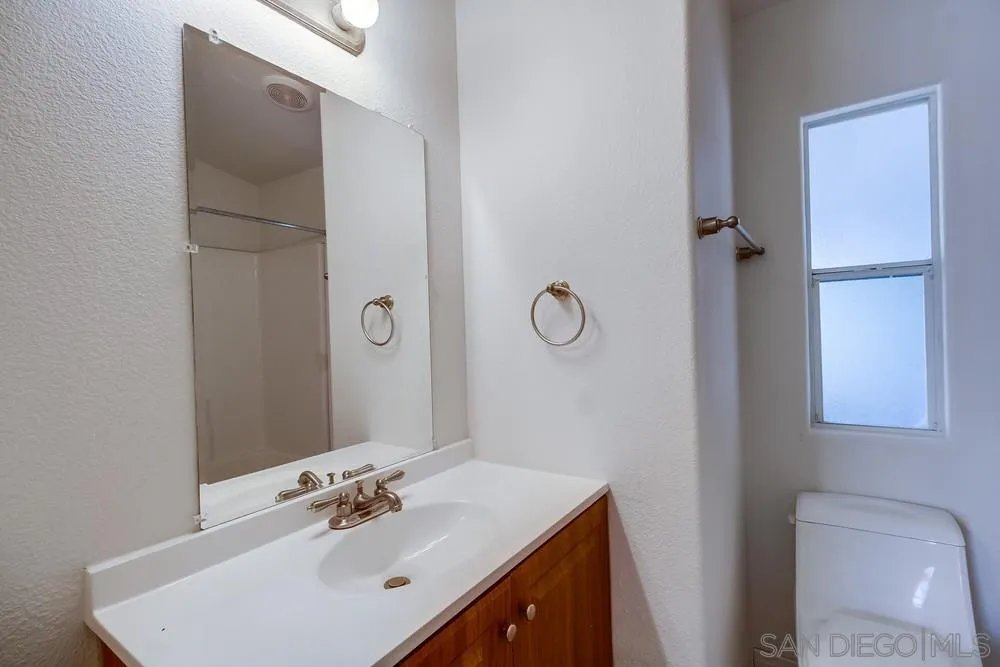 9902 Jamacha Boulevard, Unit 102 Spring Valley, CA 91977 - Photo 11 of 17 a bathroom with a sink vanity and a mirror