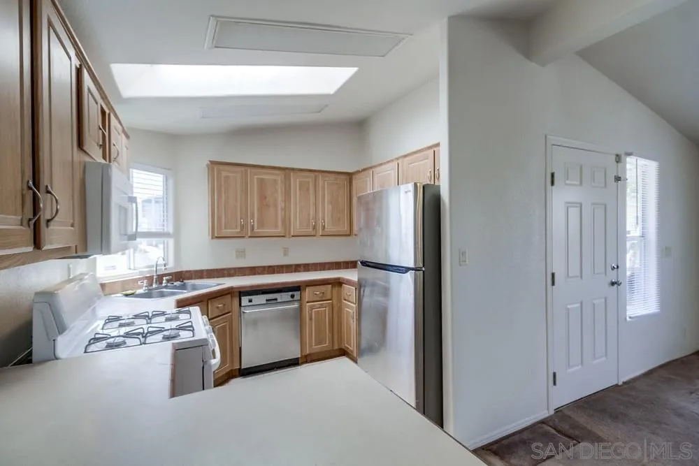 9902 Jamacha Boulevard, Unit 102 Spring Valley, CA 91977 - Photo 2 of 17 a kitchen with stainless steel appliances granite countertop a refrigerator and a stove
