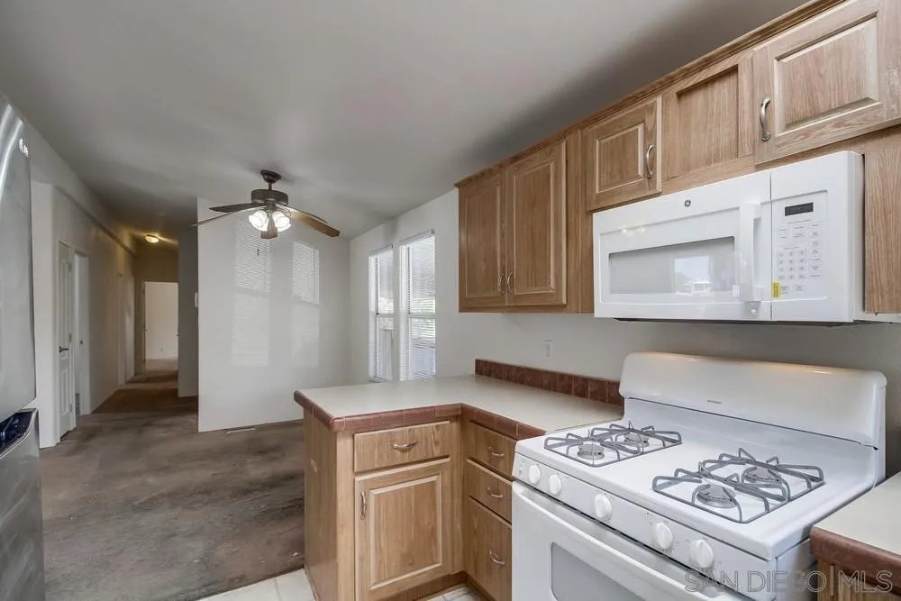 9902 Jamacha Boulevard, Unit 102 Spring Valley, CA 91977 - Photo 5 of 17 a kitchen that has a lot of cabinets a island and appliances in it