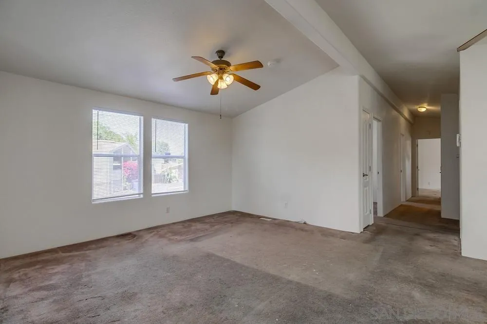 9902 Jamacha Boulevard, Unit 102 Spring Valley, CA 91977 - Photo 8 of 17 an empty room with windows and chandelier fan