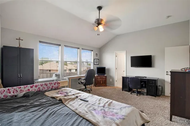a bedroom with a bed a couch and large window