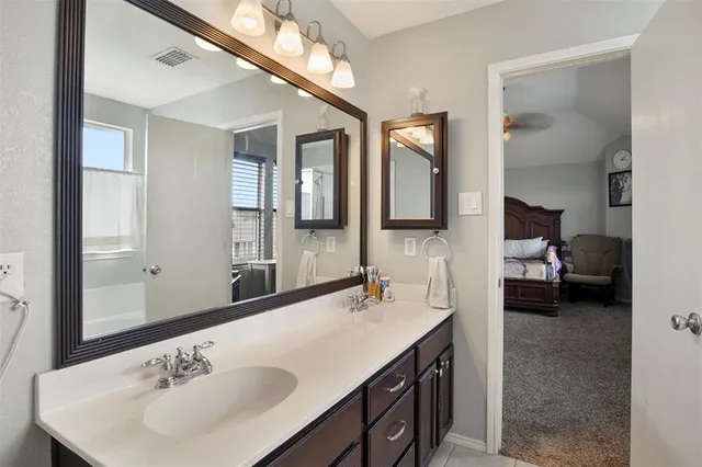 a en suite bathroom with a double vanity sink and a mirror
