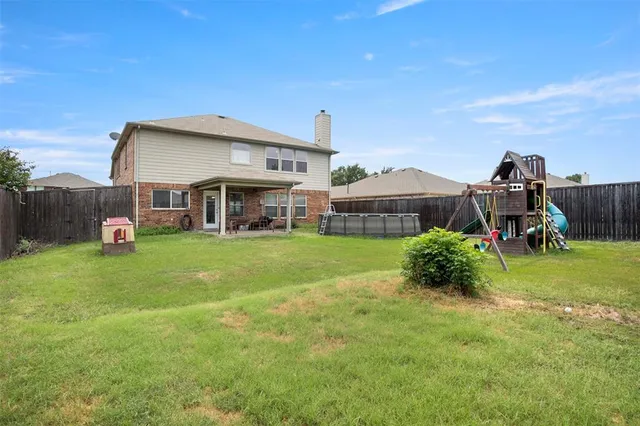 a view of a house with a backyard and a patio