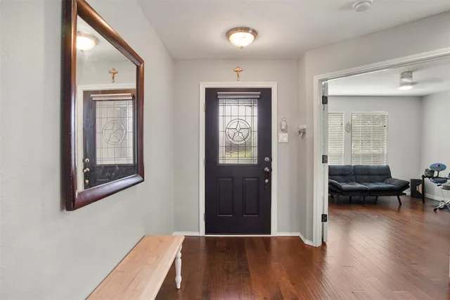 a view of a livingroom with wooden floor and furniture