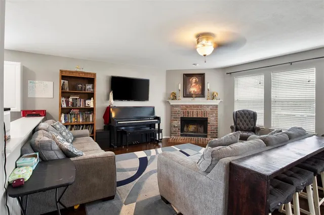 a living room with furniture a fireplace and a flat screen tv