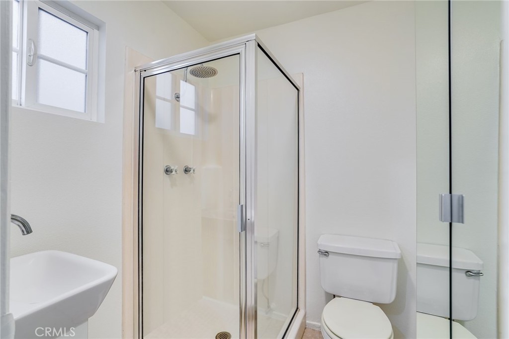 705 Iris Avenue Corona del Mar, CA 92625 - Photo 24 of 36 a bathroom with a granite countertop toilet a sink and shower