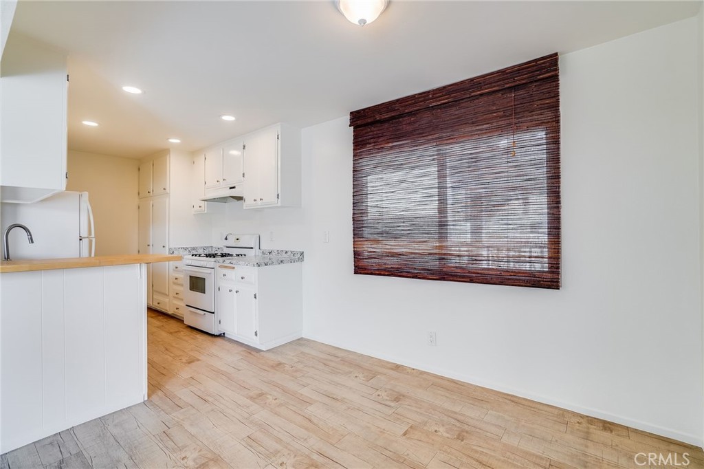 705 Iris Avenue Corona del Mar, CA 92625 - Photo 28 of 36 a kitchen with white cabinets and wooden floor