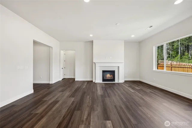 a view of empty room with wooden floor and fireplace
