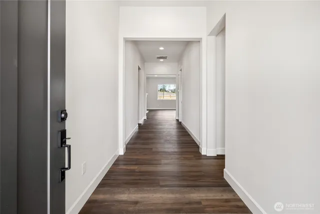 a view of a hallway with wooden floor
