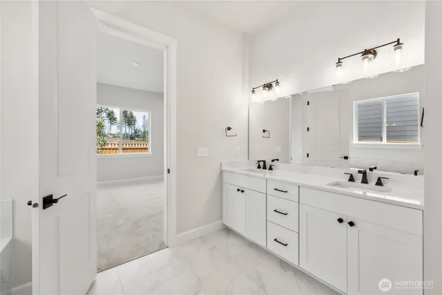 a spacious bathroom with double sink a mirror a window and a shower