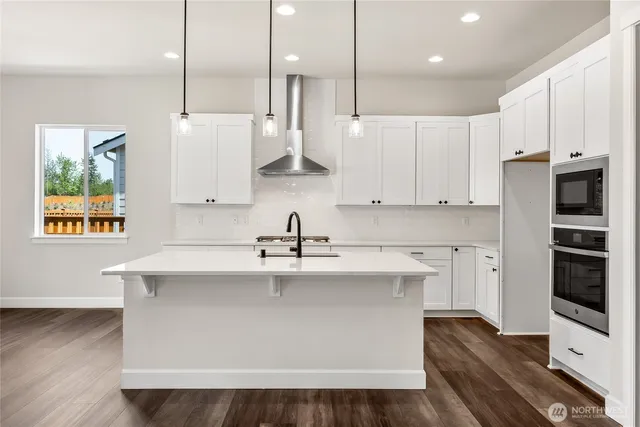 a kitchen with stainless steel appliances granite countertop a sink a stove and a refrigerator