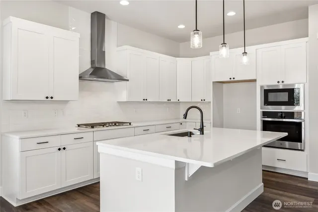 a kitchen with stainless steel appliances a sink a stove and a wooden floors