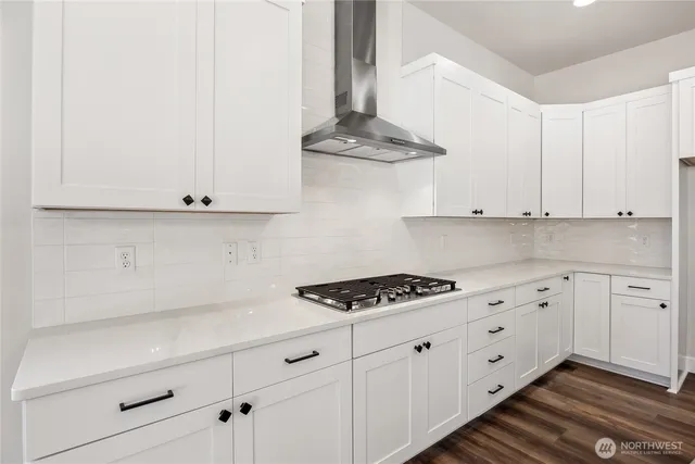 a kitchen with white cabinets and appliances