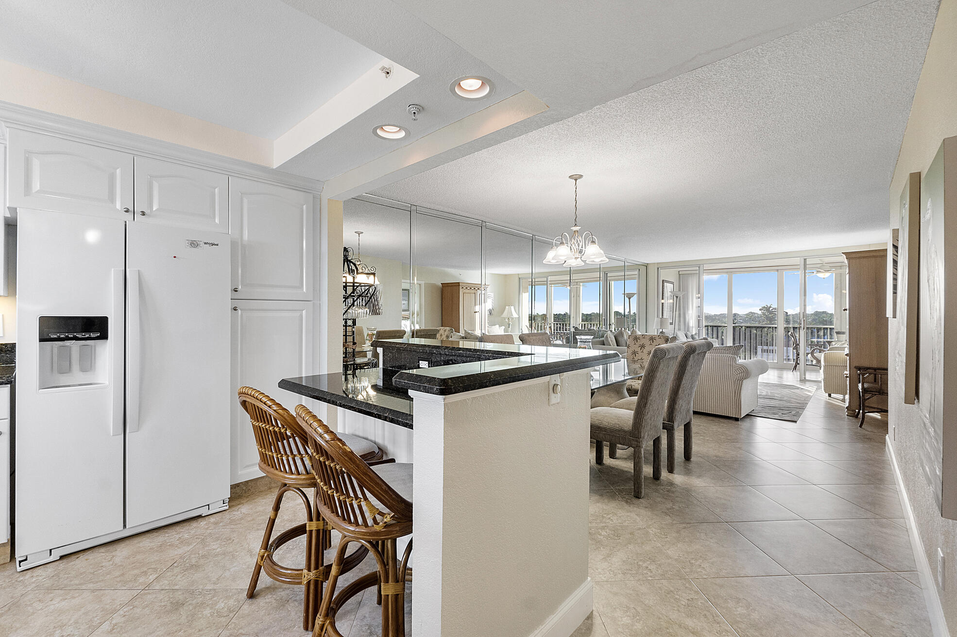 3310 South Ocean Boulevard, Unit 629D Highland Beach, FL 33487 - Photo 7 of 35 a kitchen with a table chairs refrigerator and microwave