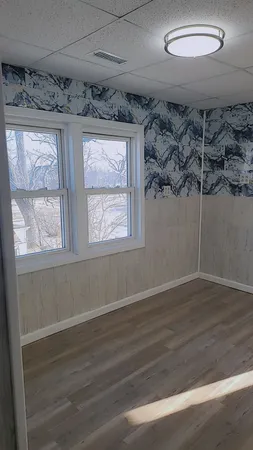 a view of a room with wooden floor and windows