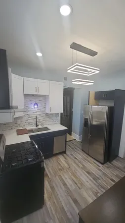 a large kitchen with stainless steel appliances granite countertop a stove a sink dishwasher and a refrigerator