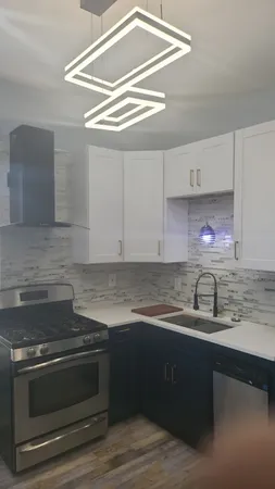 a kitchen with granite countertop a sink stainless steel appliances and cabinets