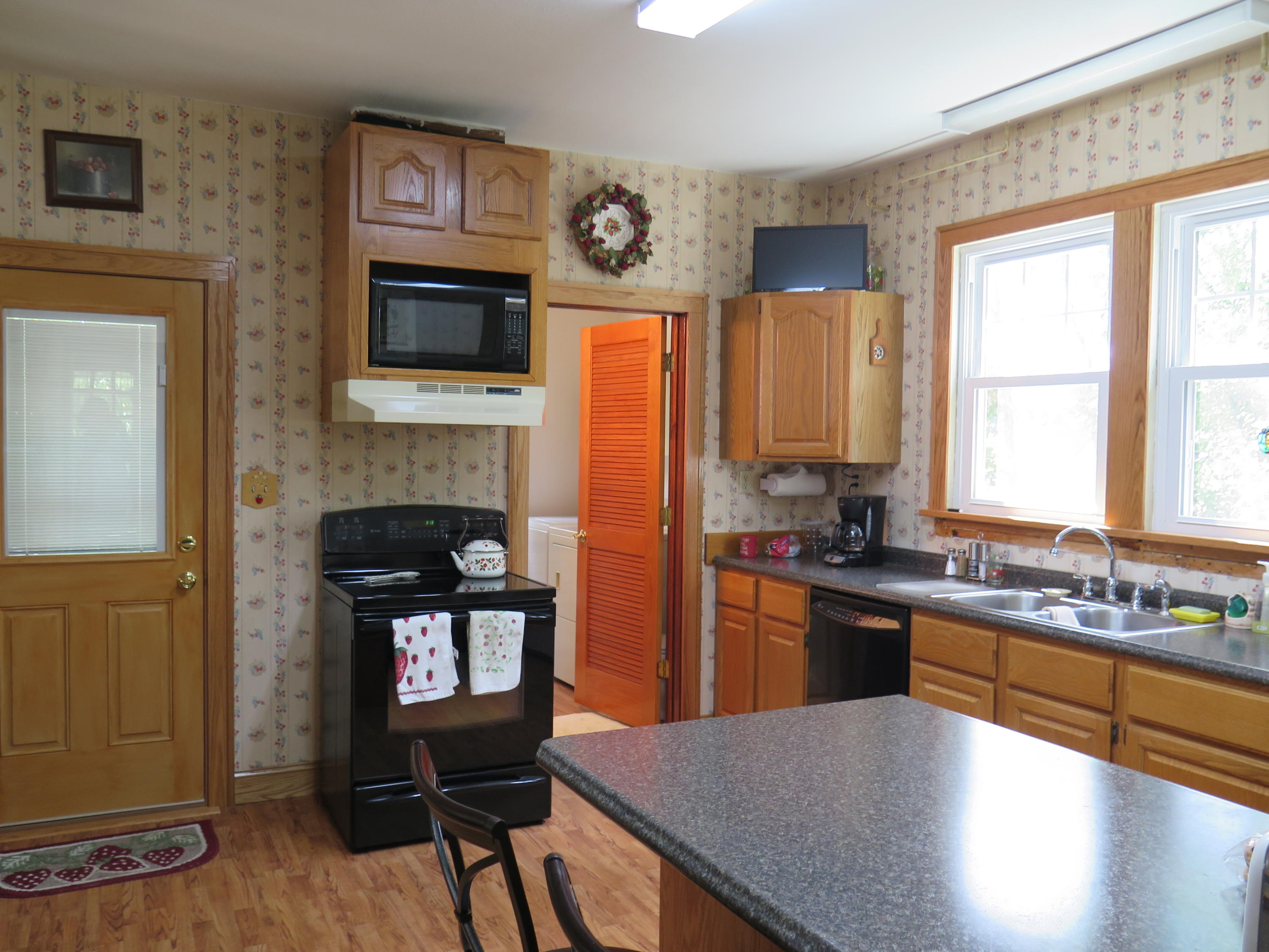 2315 Rutrough Road Southeast Roanoke, VA 24014 - Photo 5 of 38 a kitchen with stainless steel appliances granite countertop a stove top oven a sink dishwasher and a fireplace with wooden floor