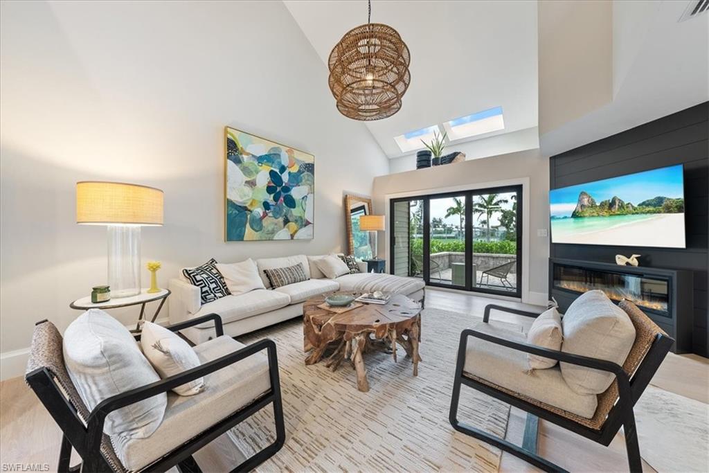 a living room with furniture a chandelier and a large window