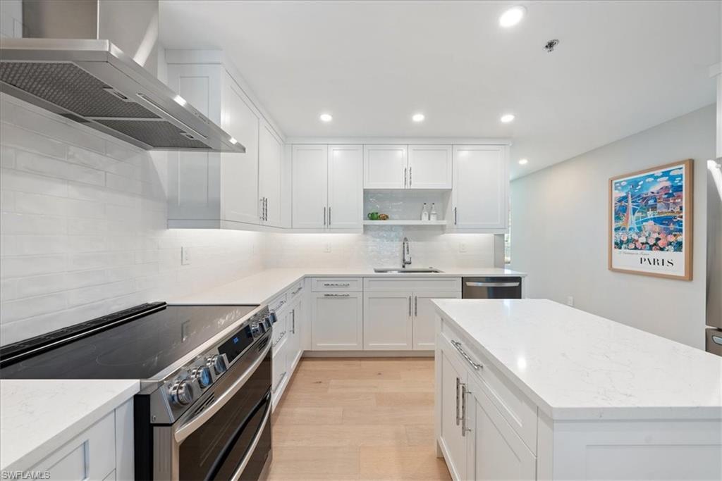 569 Park Shore Drive, Unit G5 Naples, FL 34103 - Photo 16 of 45 a kitchen with a stove sink and cabinets