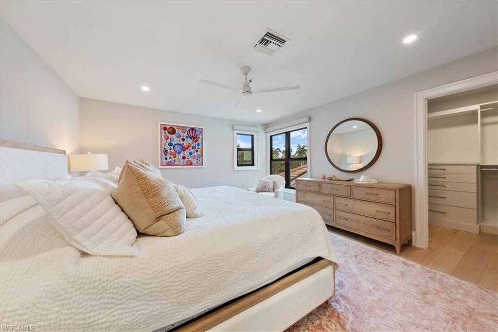 569 Park Shore Drive, Unit G5 Naples, FL 34103 - Photo 24 of 45 a bedroom with a large bed and a chandelier