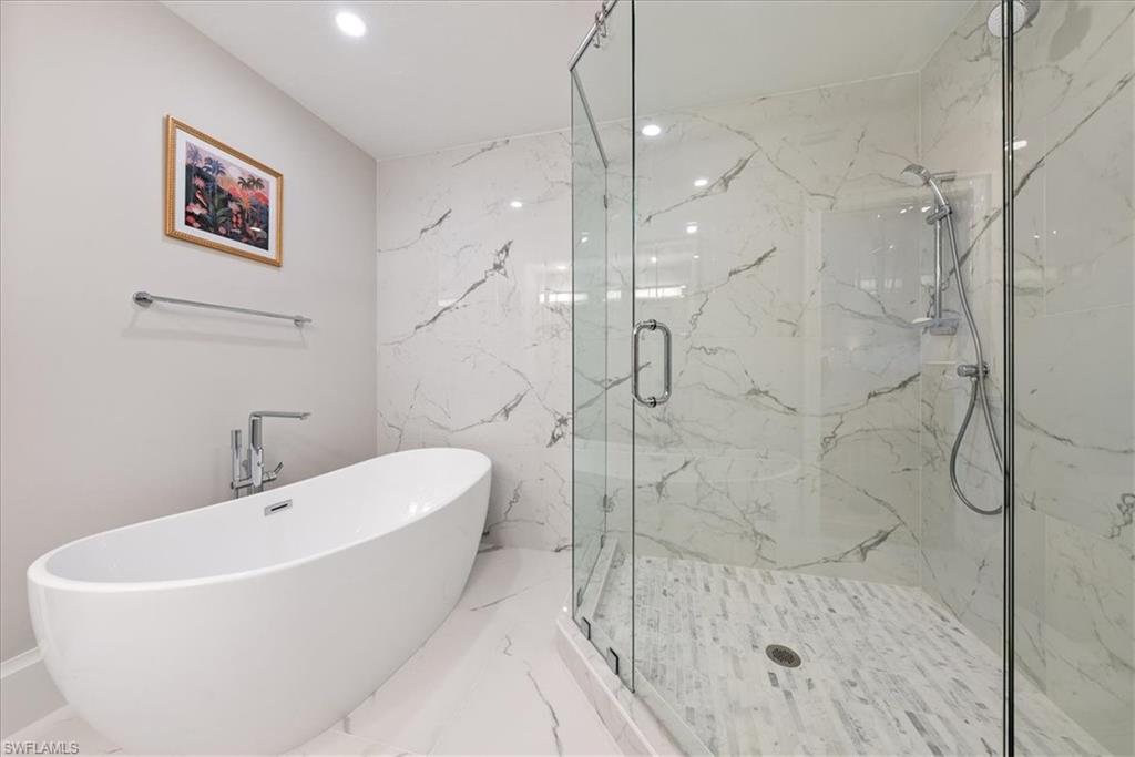 569 Park Shore Drive, Unit G5 Naples, FL 34103 - Photo 26 of 45 a white bath tub sitting next to a bathroom shower