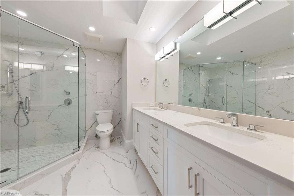 569 Park Shore Drive, Unit G5 Naples, FL 34103 - Photo 27 of 45 a spacious bathroom with a shower sink mirror and a toilet