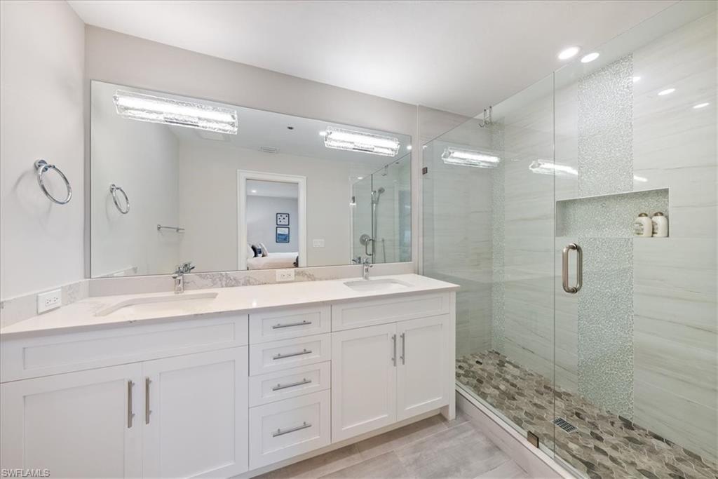 569 Park Shore Drive, Unit G5 Naples, FL 34103 - Photo 31 of 45 a bathroom with a double vanity sink mirror and shower