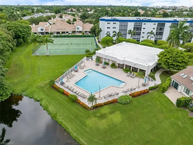 a view of a wooden house with a yard and potted plants