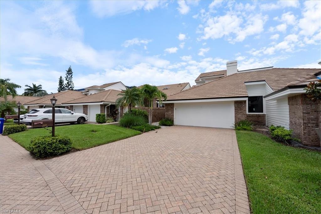 569 Park Shore Drive, Unit G5 Naples, FL 34103 - Photo 43 of 45 a front view of a house with a yard and garage