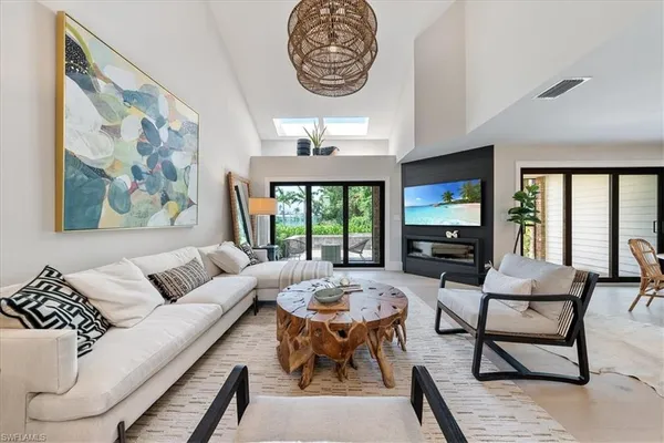 a living room with furniture a table and a large window