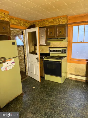 a utility room with stainless steel appliances wooden floor and a fireplace