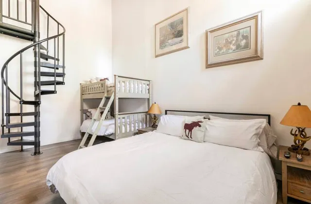 a bedroom with a bed and wooden floor