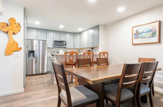 a dining room with stainless steel appliances a table and chairs