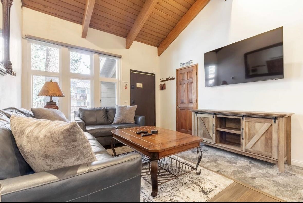 2252 Meridian Boulevard, Unit 39 Mammoth Lakes, CA 93546 - Photo 6 of 32 a living room with furniture a flat screen tv and a floor to ceiling window