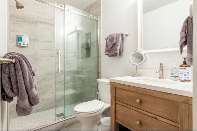 a bathroom with a sink a toilet and shower