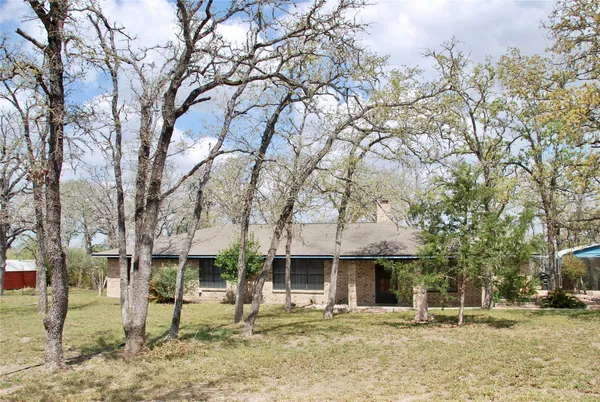 a backyard of a house with barbeque oven and trees