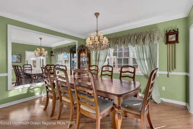 a dining room filled chandelier and wooden floor